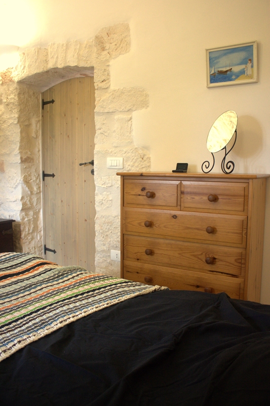 slaapkamer in stonehouse met tweepersoonsbed en een ladekast naast de deur