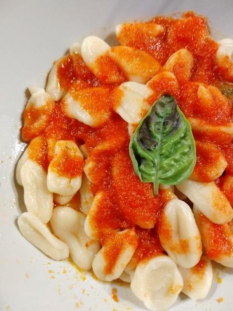 bereide oricchiette pasta met tomatensauce en opgemaakt met een basiclicum blaadje